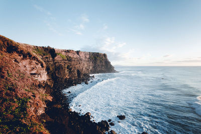 Scenic view of rock formation by sea against sky