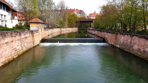 Canal amidst buildings and trees