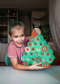 Cute girl preparing christmas decoration at home