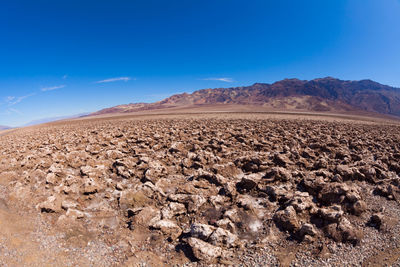 Scenic view of desert against blue sky