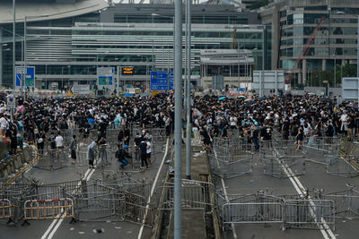 Crowd standing on road in city