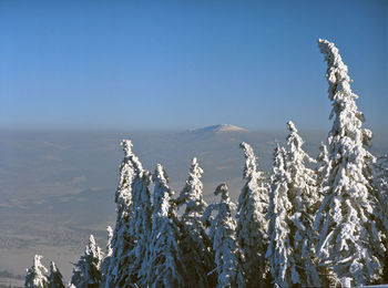 Scenic view of snow covered mountains against clear blue sky