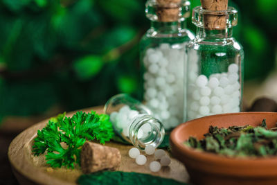 Close-up of herbs and homeopathic medicine in tray on table