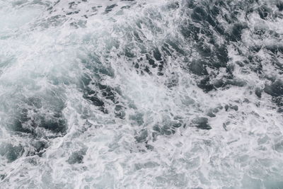 Splashing sea water with foam and bubbles at timang beach in sunny day, yogyakarta, indonesi