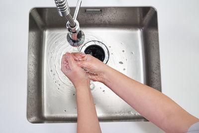 Midsection of woman with water in bathroom at home