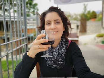 Portrait of smiling woman drinking glass