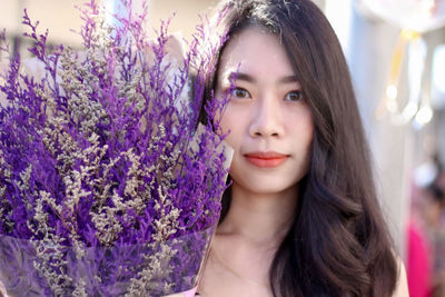 Portrait of beautiful woman against purple flowering plants