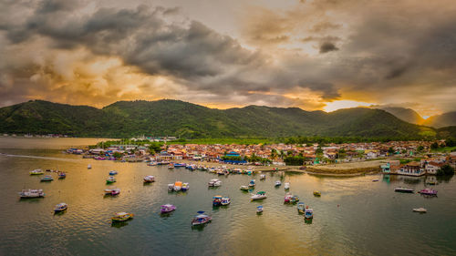 High angle view of crowd at beach against sky during sunset