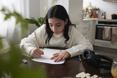 Girl doing homework at dining table