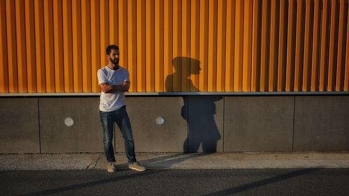 Portrait of man standing against wall