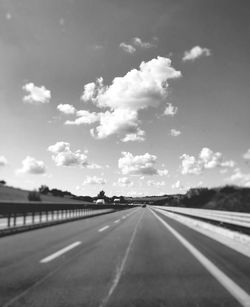 Empty road against cloudy sky