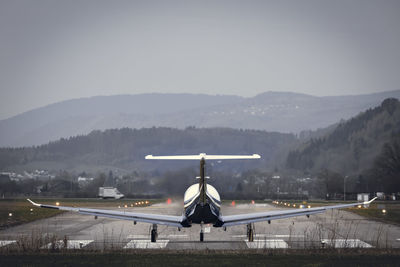 Airplane on airport runway against sky