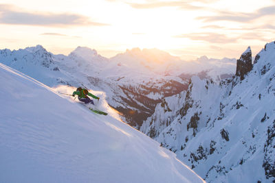 Man skiing on snowcapped mountain against sky