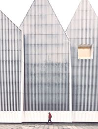 Low angle view of man standing by building against sky