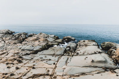 Rocks on beach against sky