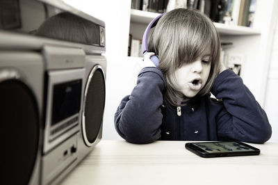 Portrait of cute boy sitting on mobile phone