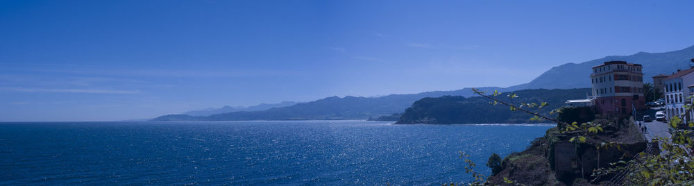 Scenic view of sea by buildings against sky