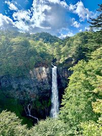 Scenic view of waterfall against sky