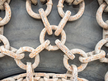 Wheel chains with sandy dirt on huge tire of construction or quarry machine. chains with ring chain