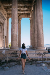 Rear view of woman standing against built structure