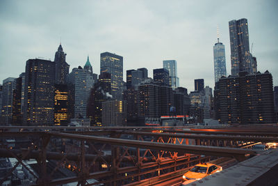 Illuminated modern buildings in new york city against sky at dusk