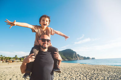 Boy sits on his father's shoulders