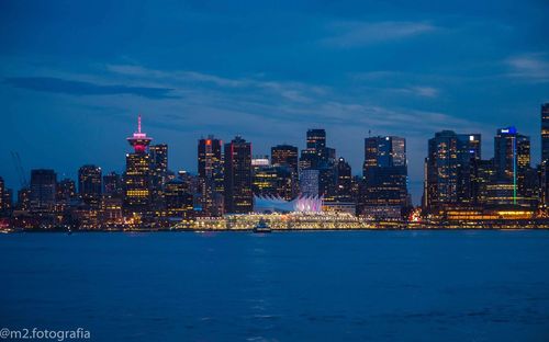 Illuminated buildings in city against sky