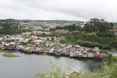 High angle view of townscape by river against sky