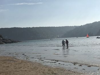 People on beach against sky