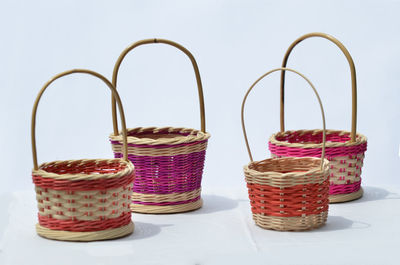 Close-up of jar in basket on table against white background