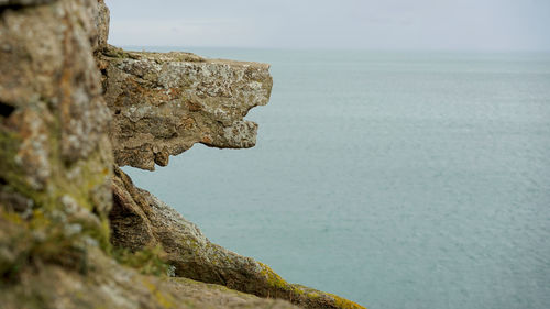 Rock formations by sea against sky