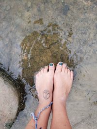 Low section of woman standing in water