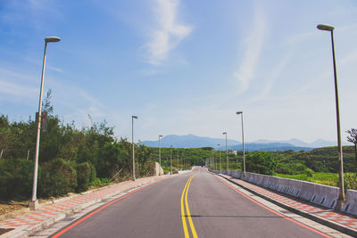 Empty road against cloudy sky
