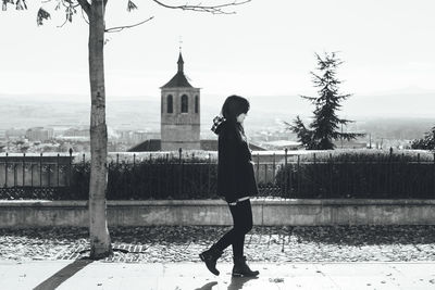 Side view of woman walking on footpath