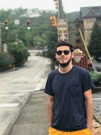 Portrait of young man wearing sunglasses standing outdoors