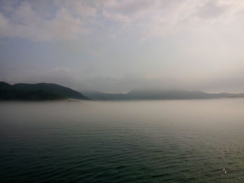 Scenic view of lake against cloudy sky