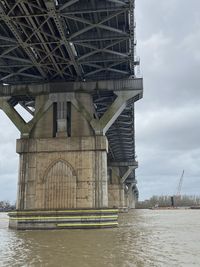 Low angle view of bridge over river against sky