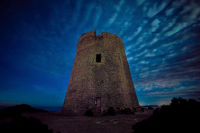 Low angle view of old building against sky at night