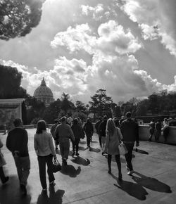 People walking on street against sky