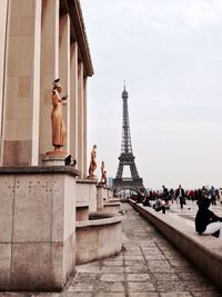 People by eiffel tower against sky in city