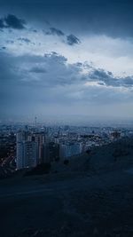 Aerial view of buildings against cloudy sky