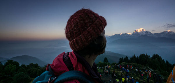 Rear view of woman looking at mountains against sky