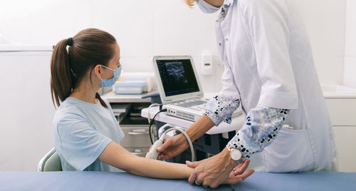 Midsection of doctor examining patient