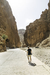 Rear view of man walking on road