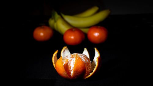 Close-up of oranges on table against black background