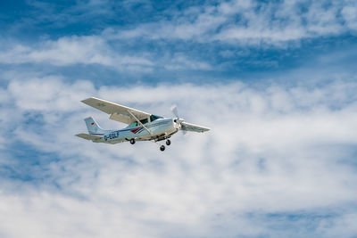 Low angle view of airplane flying against sky