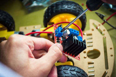 Cropped hands repairing machine part in workshop