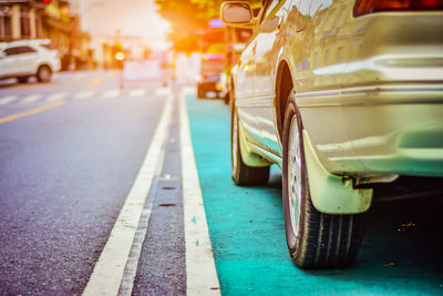 Close-up of yellow car on road