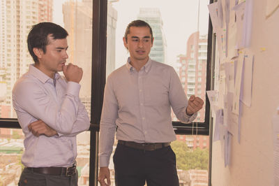 Businessman discussing graphs with colleague in office