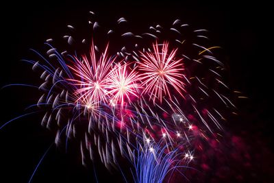 Low angle view of firework display at night